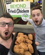 2soyjaks arm beard beyond_chicken beyond_meat brown_hair clothes ear food fried_chicken glasses hair hand holding_object irl mustache open_mouth pointing sign store stubble variant:two_pointing_soyjaks // 1125x1374 // 158.4KB